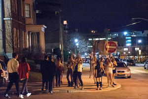 A group of students meet on the corner of Marshall Street and Walnut Place, surprised to see each other on a night out. 