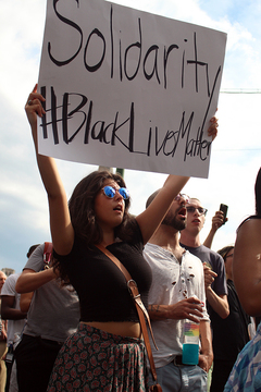 Alexis Rinck, a Syracuse University student, holds a sign promoting solidarity of races for the Black Lives Matter movement.