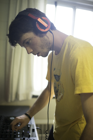 JP Hadley DJs with his equipment in a dorm room. Hadley writes for the music blog, Dance Rebels.