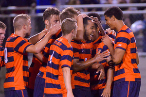 Syracuse players congratulate Ben Polk on one of his three goals. The forward's hat trick were his first tallies in an SU uniform, leading the hosts to a 5-0 win.