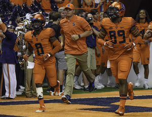 Brad Wittke (center) and Eric Dungey knocked down Boston College defensive back William Harris during a Syracuse game on Saturday. 