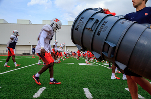 Syracuse football players stretch in preparation for the day's activities.