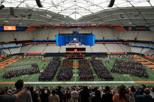 Dressed in caps and gowns, graduating seniors await their time to walk the stage at the commencement ceremony.
