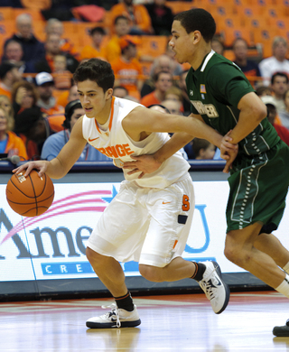 Syracuse guard Nolan Hart dribbles around a defender.