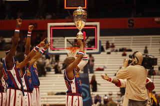 Scooter raises the World Cup Championship trophy while his teammates celebrate in the background. 