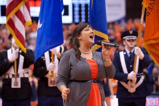 Brenna McConaughey, a marketing coordinator in the for SU Atheletics is accompanied by Syracuse University ROTC as she performs the national anthem prior to tip-off of Syracuse's 78-57 victory over DePaul.