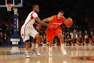 Michael Carter-Williams drives left through Louisville's pressure.