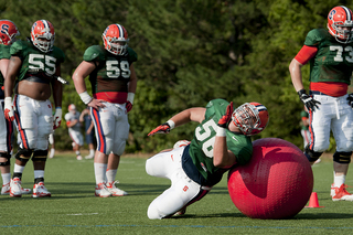 Freshman offensive lineman John Miller blocks around a giant red ball at practice on Tuesday. The interior offensive lineman were working on pulling plays.