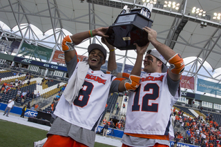 Orange midfielder Hakeem Lecky and DeJoe hoist the ACC trophy.