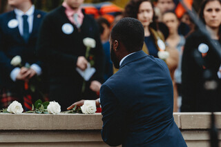 Scholar Azarius Williams places his rose on top of the Remembrance Wall in honor of Scott Cory.