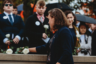 Scholar Mary Kate Washburn places her rose in honor of Julianne Kelly.