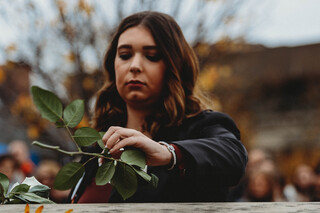 Scholar Gabrielle Caracciolo places her rose in honor of Mark Tobin.