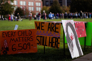 People at the event brought signs addressing the residential school system, which systematically broke up Indigenous children from their families for the purpose of “reeducation.” Children in the schools were abused and forbidden from practicing their own culture. While at the school, thousands died.